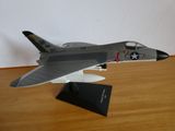 une maquette d'avion de chasse posée sur une table en bois