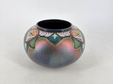 a colorful vase sitting on a table with a white background