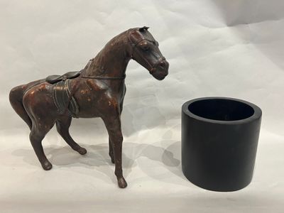 a statue of a horse standing next to a black vase
