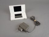 a white nintendo wii game console and charger on a table