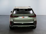 the rear end of a green bmw suv parked in a room