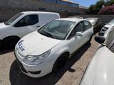une voiture blanche garée dans un parking à côté d'autres voitures
