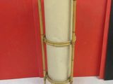 a tall bamboo planter on the floor next to a red wall