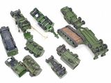 many toy army vehicles that are on a white surface