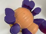 purple and orange plastic crab toy sitting on top of a white table