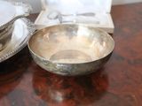 a silver bowl sitting on a table next to a silver plate