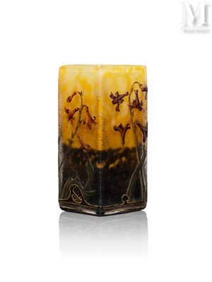 une bougie jaune et noire ornée de fleurs, posée sur une surface blanche