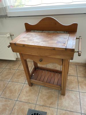 a wooden table with a drawer underneath it on a tiled floor