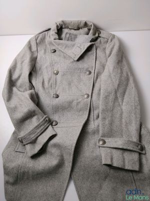 an image of a gray coat sitting on top of a white table