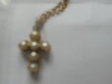 un collier en or orné de perles et d'une croix