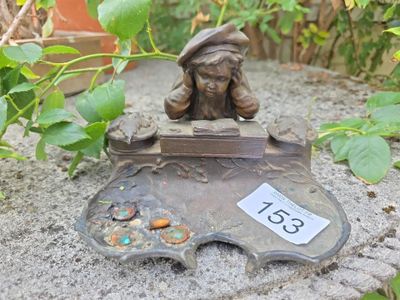a small statue of a boy sitting on top of a rock