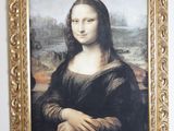 a picture of a painting of a woman in a gold frame on the wall