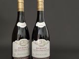 two bottles of wine sitting next to each other on a table