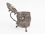 an antique silver cup with a spoon sitting on top of it