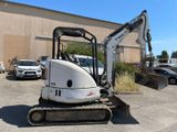 an image of a small excavator parked in a parking lot