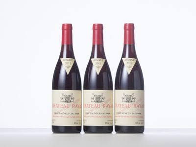 three bottles of red wine sitting on top of a white table