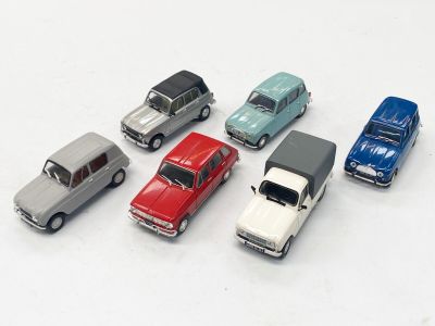 plusieurs petites voitures sont alignées sur une surface blanche