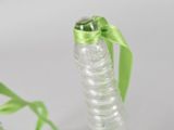 a bottle with a green ribbon tied to it