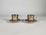 une paire de tasses et soucoupes en métal argenté