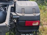 a truck that is parked in the grass with its back end open