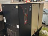 un gros compresseur d'air posé sur une palette dans un entrepôt