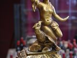 a gold figurine sitting on top of a box on a table
