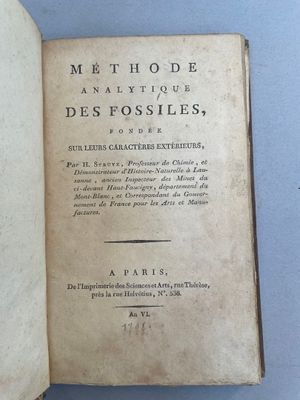un livre ouvert posé sur une table, sur fond bleu