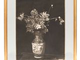 photographie en noir et blanc d'un vase contenant des fleurs, posé sur une table