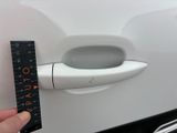 someone is measuring the length of a car door handle with a ruler