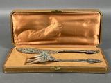 an antique silverware set in a case with a spoon and fork in it