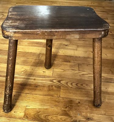 a wooden table with a black top on a hard wood floor
