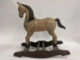 un cheval à bascule en bois avec une selle sur le dos