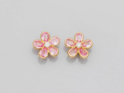 une paire de boucles d'oreilles en forme de fleurs roses et dorées