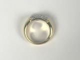 a close up of a ring on a white surface with a diamond
