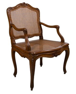 une image représentant une chaise en bois avec un dossier et des accoudoirs en osier