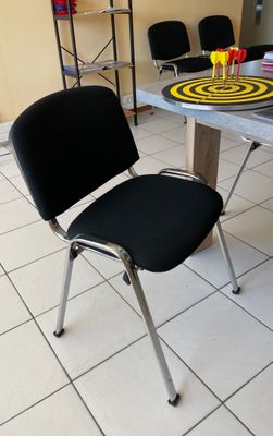 une chaise noire posée près d'une table dans une pièce