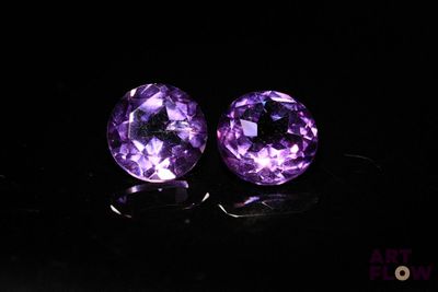 a pair of purple amethtites on a black surface