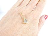 a woman ' s hand holding a gold ring with a tear on it