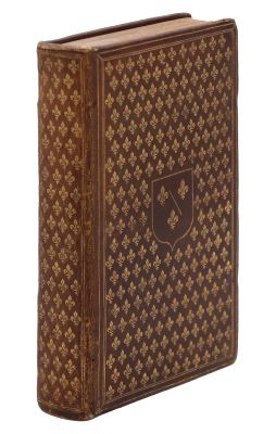 un vieux livre à la couverture brune posé sur une surface blanche
