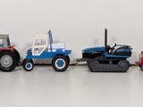 a row of toy tractors lined up on a white surface