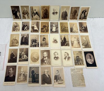 une vieille photo montrant un groupe d'hommes et de femmes assis sur une table