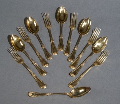 un grand nombre de cuillères et de fourchettes en argent disposées en cercle