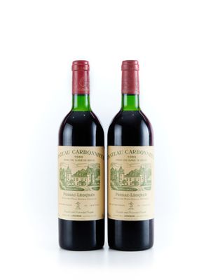 deux bouteilles de vin rouge posées l'une à côté de l'autre sur une surface blanche