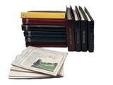 several books are stacked on top of each other on a white surface