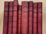 six livres rouges empilés les uns sur les autres sur une table en bois