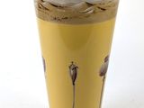 a yellow vase with a picture of a desert scene on it