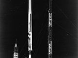 une photo en noir et blanc d'une fusée spatiale posée au sommet d'un immeuble