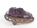 an image of a broochle with a purple stone on it