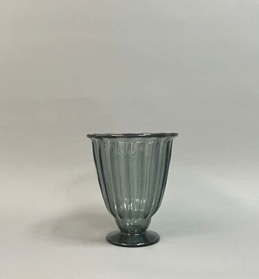 an image of a green glass vase sitting on top of a white table