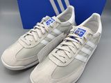 une paire de baskets adidas blanches à rayures bleues et blanches